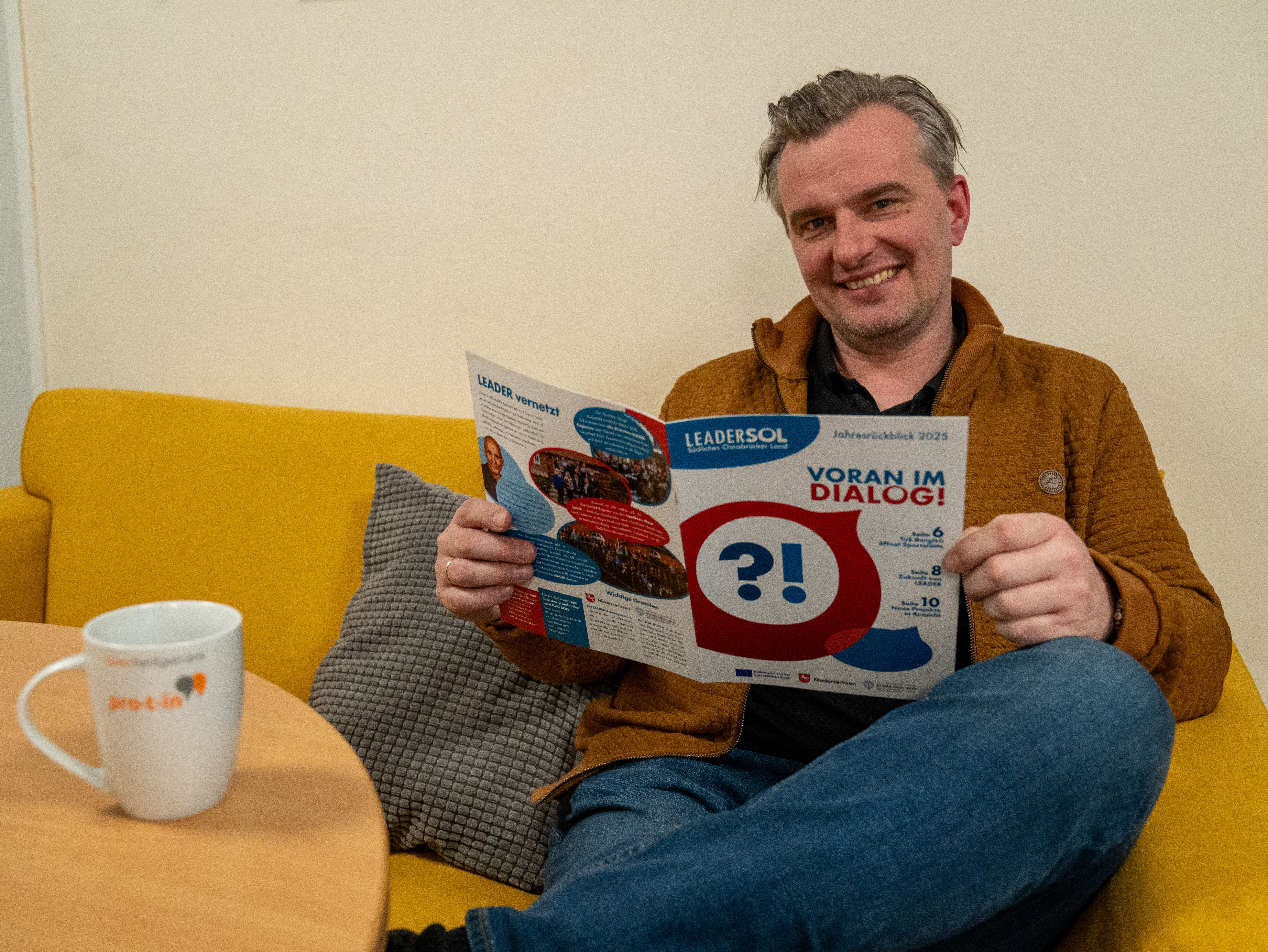 Regionalmanager Michael Ripperda sitzt auf dem Sofa und liest den Jahresrückblick 2025.